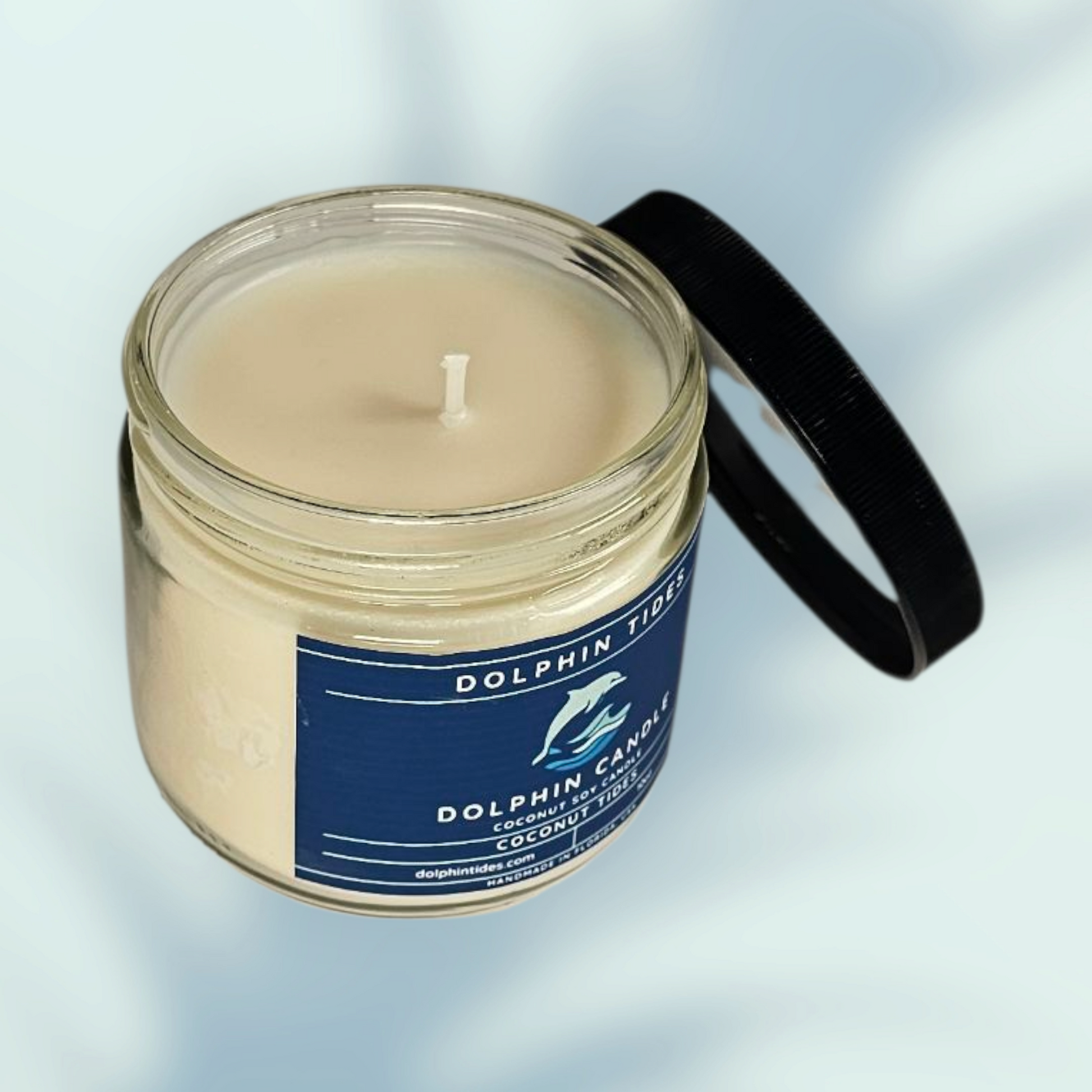Candle in a glass jar with a blue label on a light gray background
