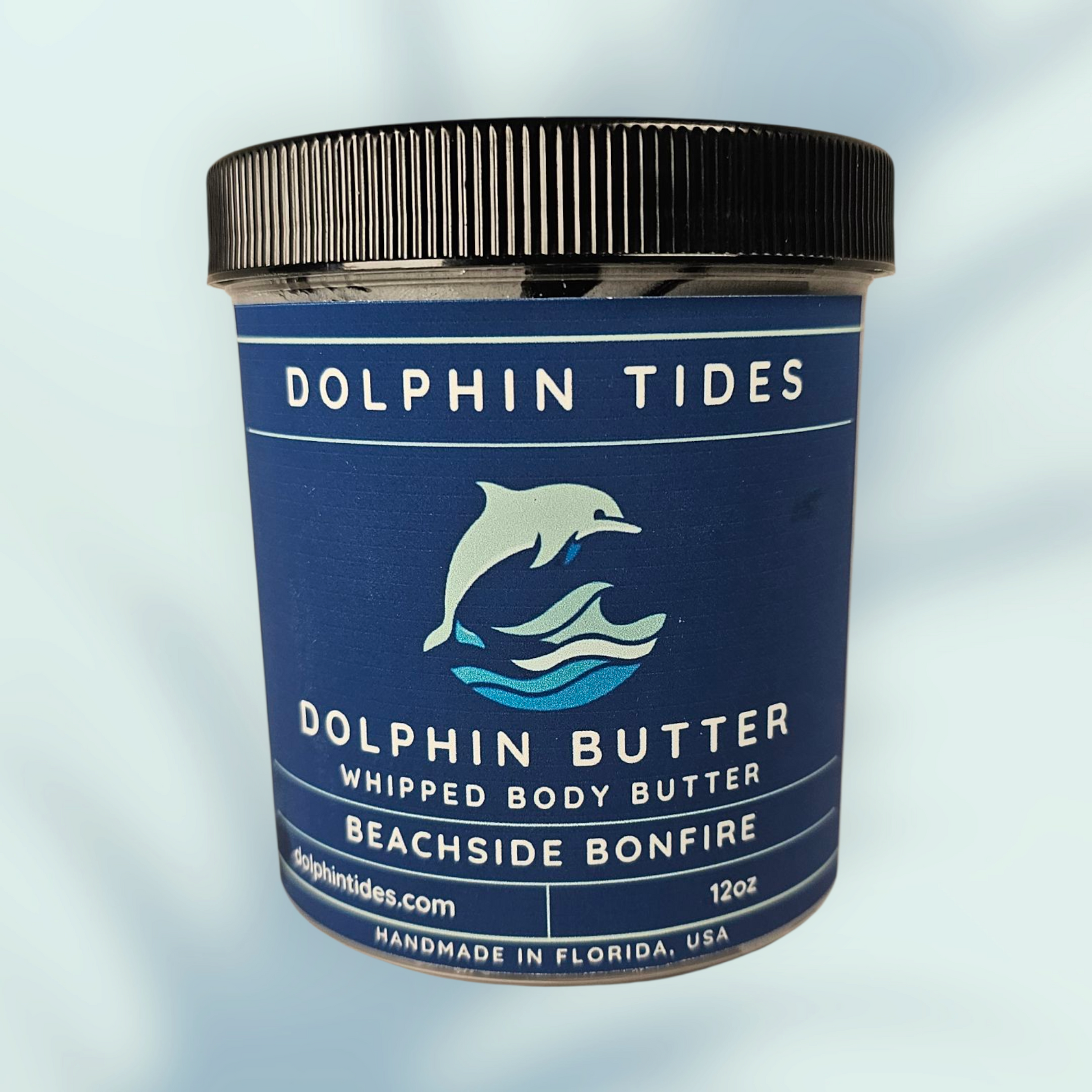Dolphin Tides whipped body butter jar on a light blue background