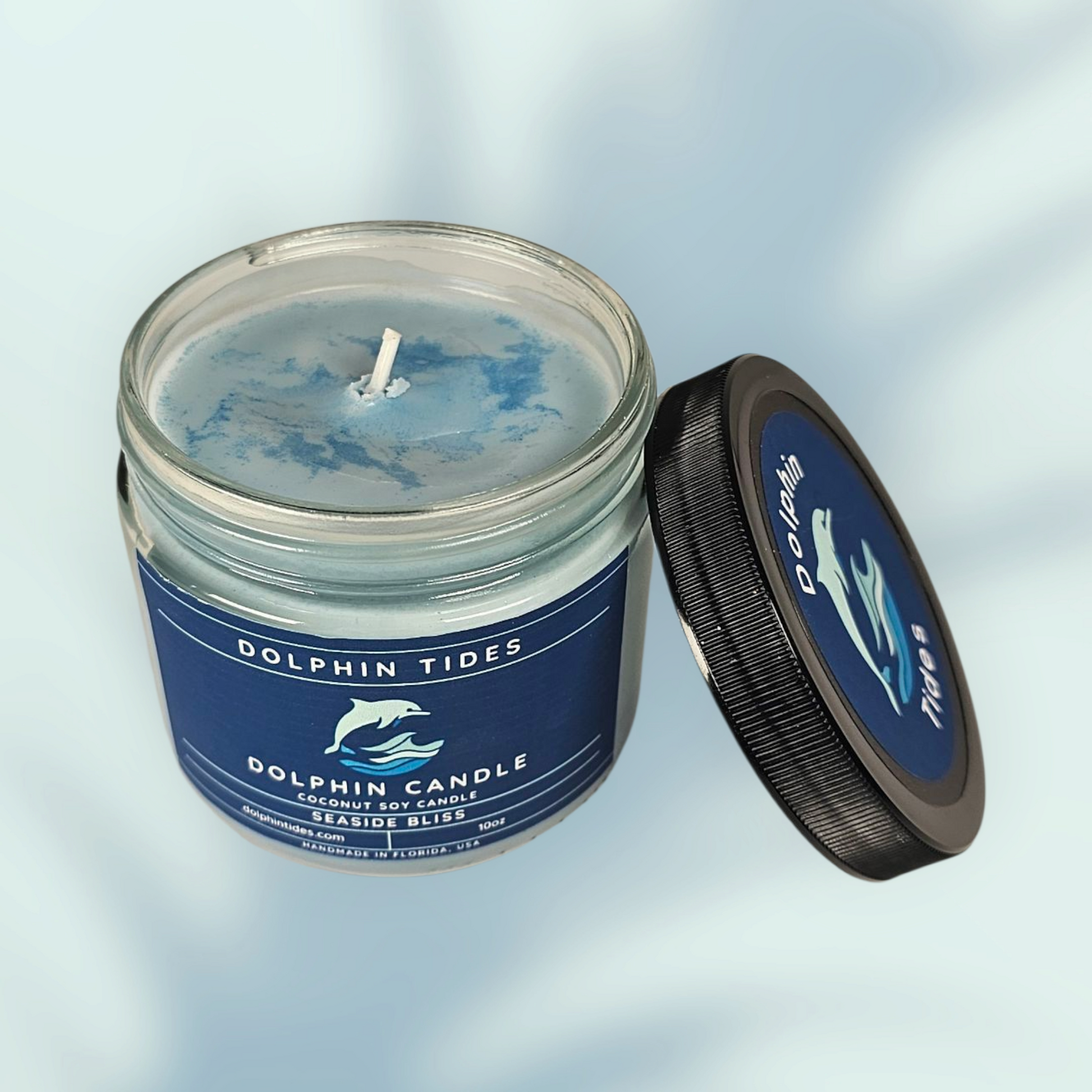 Candle in a glass jar with a blue label on a light gray background