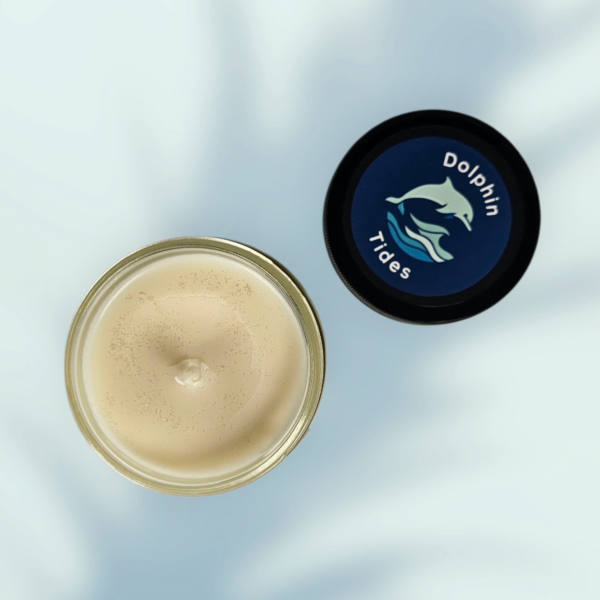 Jar of cream with a black lid featuring 'Dolphin Trace' branding on a light blue background