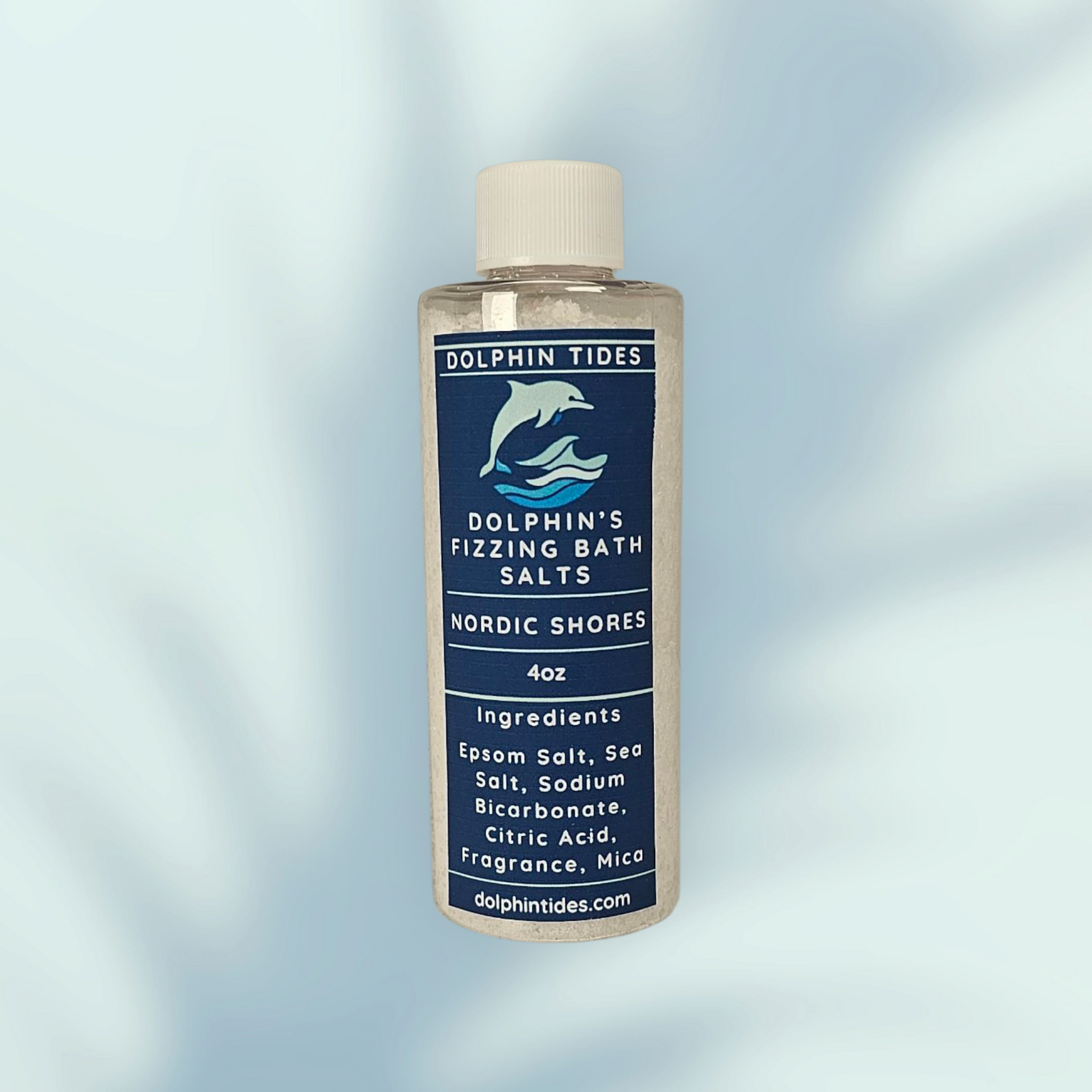 Bottle of Dolphin Tides Fizzing Bath Salts with label on a light blue background